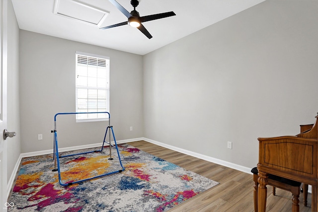 workout area with baseboards, a ceiling fan, and wood finished floors