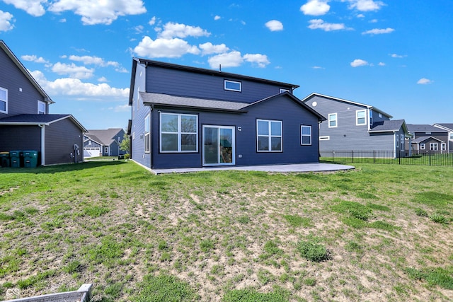 back of property featuring a lawn, a patio, fence, and a residential view