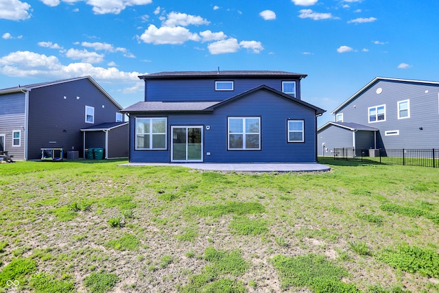 back of property with fence, central air condition unit, a lawn, and a patio area