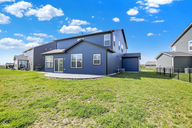 rear view of property featuring fence, central AC unit, a yard, and a patio