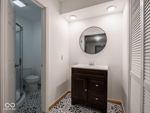 bathroom with vanity, tile patterned flooring, a shower with door, and toilet