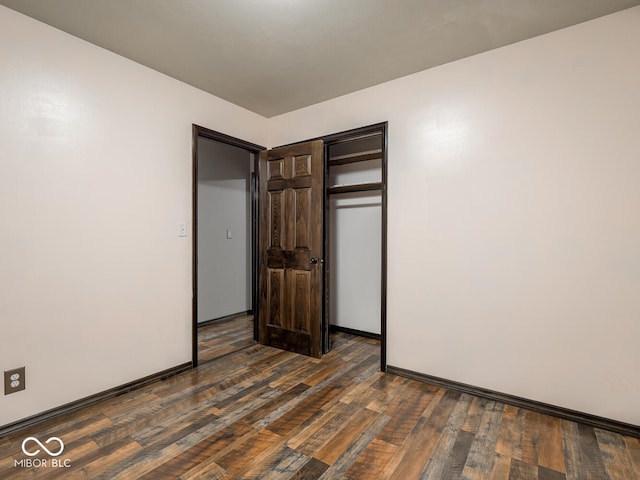 unfurnished bedroom featuring a closet and dark hardwood / wood-style floors