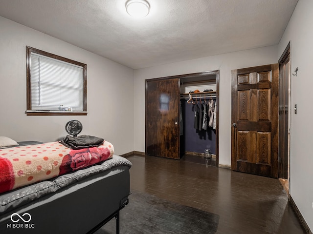 bedroom with dark hardwood / wood-style flooring, a closet, and a textured ceiling