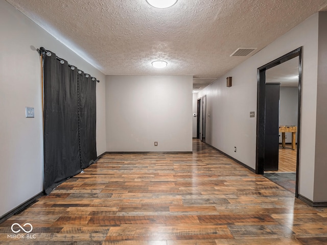 spare room featuring hardwood / wood-style flooring and a textured ceiling