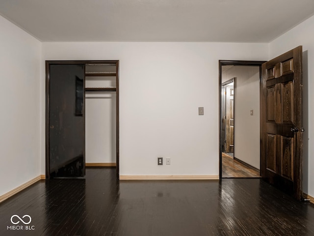 unfurnished bedroom featuring dark hardwood / wood-style floors and a closet