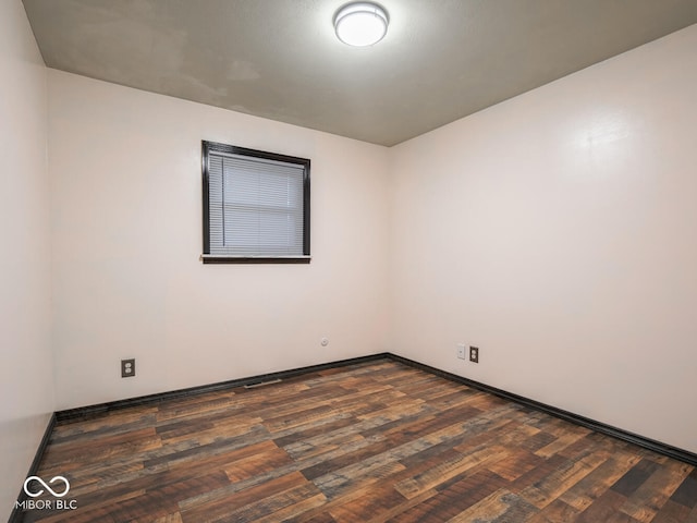 empty room with dark hardwood / wood-style flooring