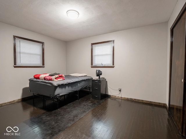 bedroom with hardwood / wood-style floors and a textured ceiling