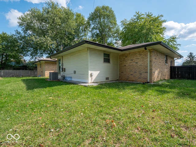 back of property featuring a yard and central air condition unit