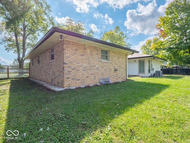 view of side of home featuring a yard and central AC unit