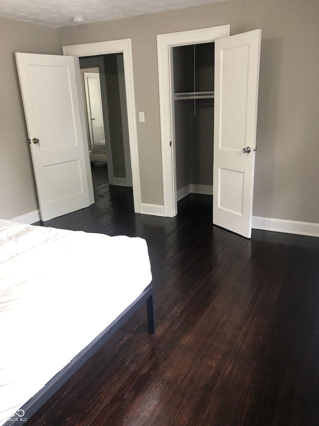 unfurnished bedroom featuring dark wood-type flooring and a closet