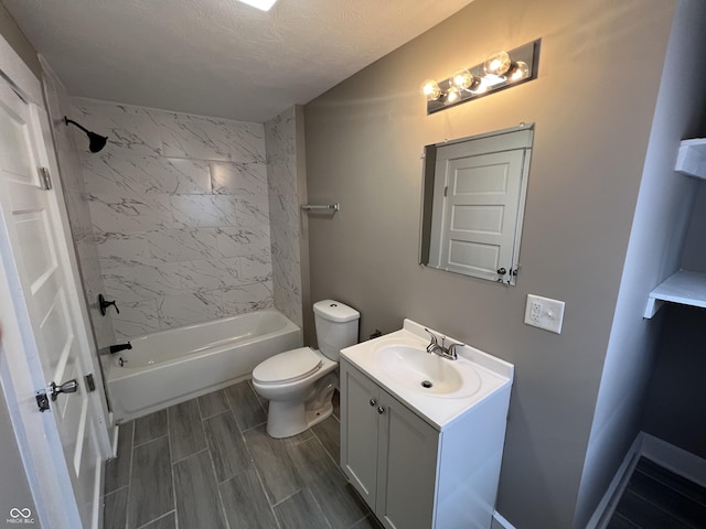 bathroom with wood finish floors, toilet, a textured ceiling, shower / tub combination, and vanity