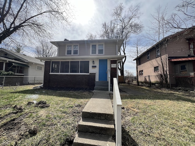 american foursquare style home featuring brick siding, a chimney, a front yard, and fence