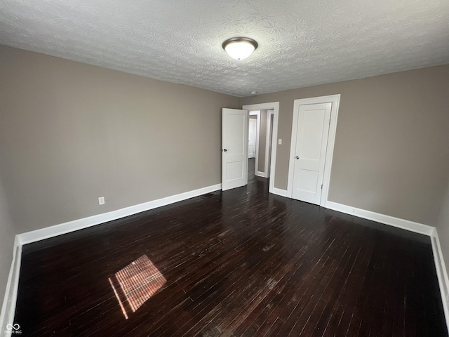 unfurnished room with baseboards, a textured ceiling, and dark wood finished floors