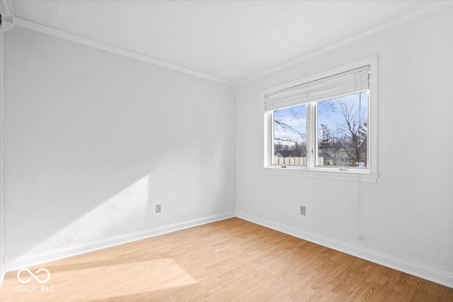 unfurnished room featuring crown molding, baseboards, and light wood-style floors