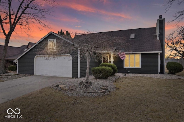 view of front of house with a garage, driveway, a chimney, and a lawn