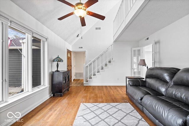 living area with light wood-type flooring, stairs, and visible vents