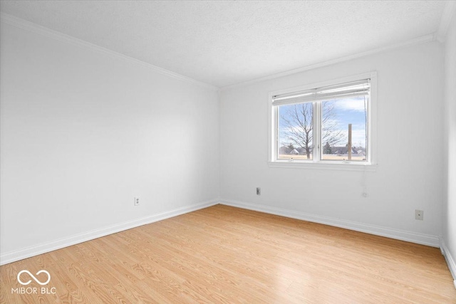 unfurnished room featuring light wood-type flooring, crown molding, baseboards, and a textured ceiling