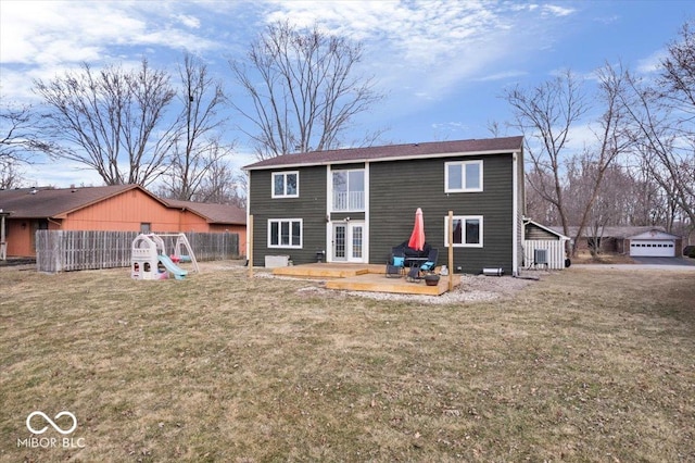 rear view of property with a yard, fence, a playground, and french doors