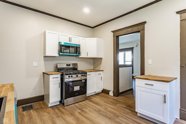 3543 N Kenwood Ave, Indianapolis, IN 46208 - kitchen with butcher block countertops, appliances with stainless steel finishes, wood finished floors, white cabinets, and ornamental molding