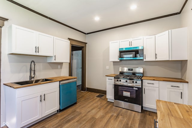 3543 N Kenwood Ave, Indianapolis, IN 46208 - kitchen featuring butcher block countertops, stainless steel appliances, crown molding, dark wood finished floors, and white cabinets