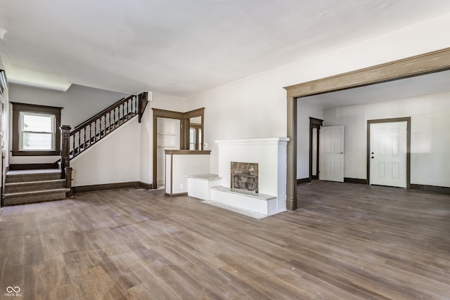 3543 N Kenwood Ave, Indianapolis, IN 46208 - unfurnished living room featuring wood finished floors, stairway, and a fireplace with raised hearth