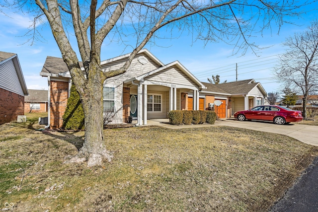 view of front of property featuring a porch, concrete driveway, brick siding, and a front lawn