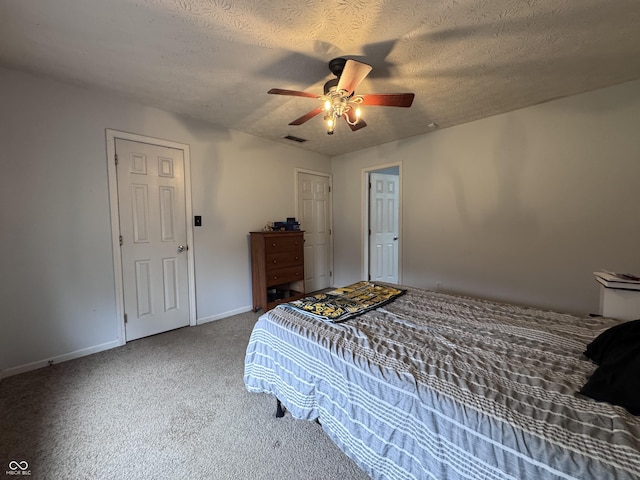 bedroom with visible vents, a ceiling fan, carpet, baseboards, and a textured ceiling