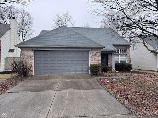 ranch-style house with concrete driveway, a shingled roof, an attached garage, and brick siding