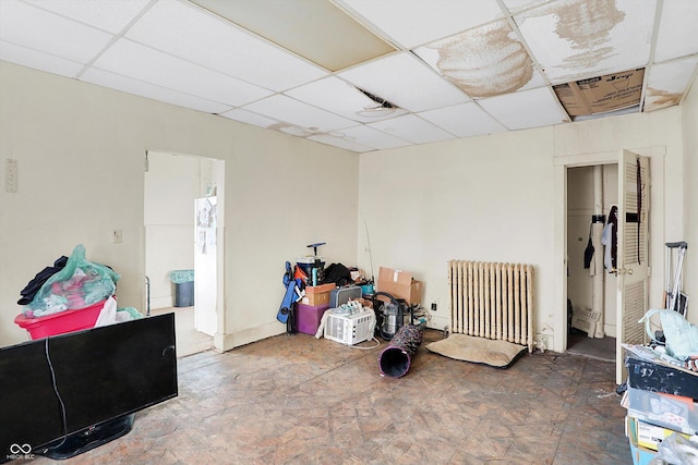 interior space with radiator and a paneled ceiling