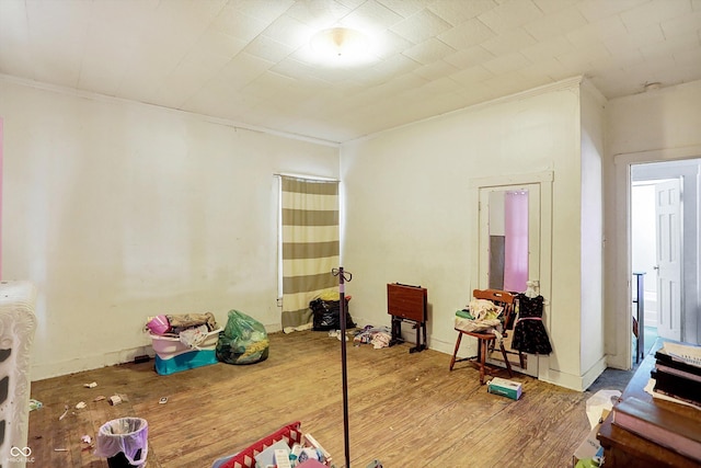 game room with hardwood / wood-style floors and crown molding