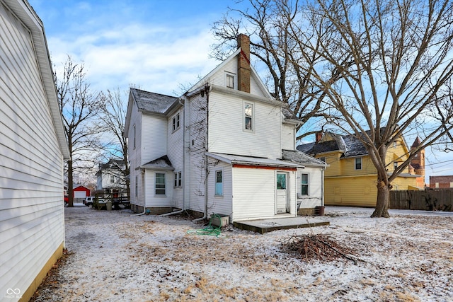 view of snow covered rear of property