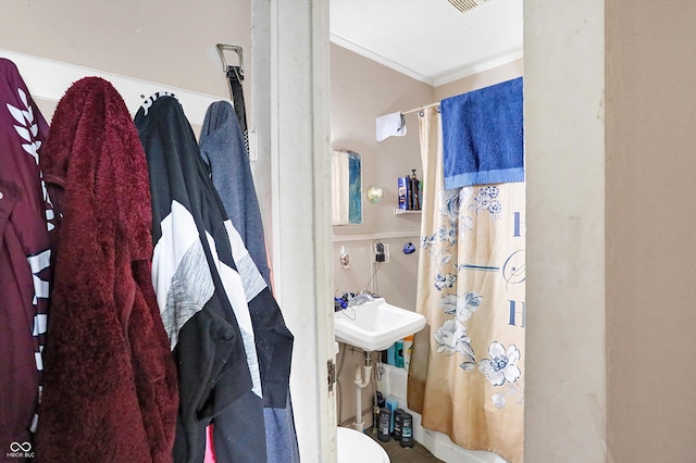 bathroom with crown molding, curtained shower, and toilet