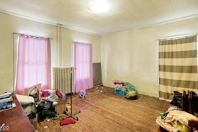 bedroom featuring crown molding, radiator, and hardwood / wood-style floors