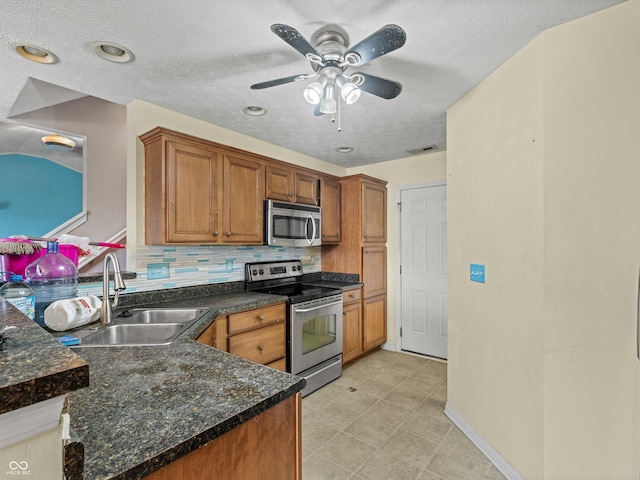 kitchen featuring stainless steel appliances, brown cabinetry, and a sink