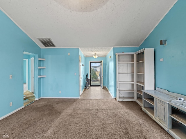 unfurnished living room featuring a textured ceiling, light carpet, visible vents, vaulted ceiling, and crown molding