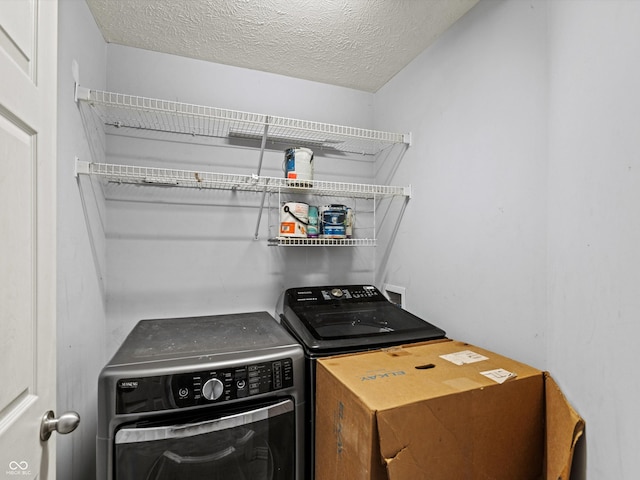 laundry room with laundry area, a textured ceiling, and independent washer and dryer