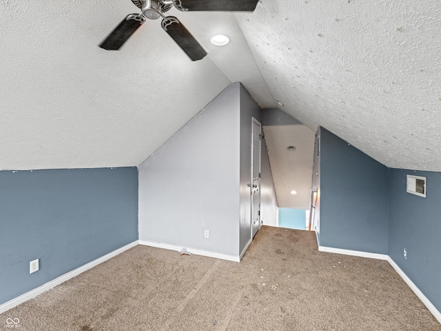 additional living space featuring a textured ceiling, ceiling fan, carpet flooring, and baseboards