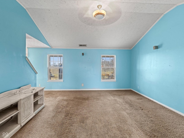 unfurnished living room with baseboards, visible vents, lofted ceiling, a textured ceiling, and carpet floors