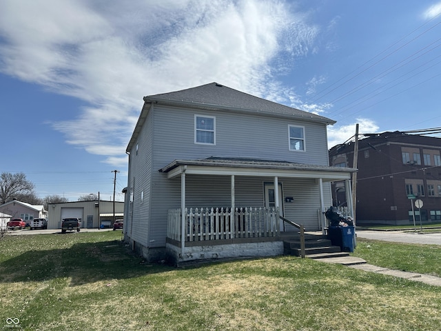 view of front facade featuring a garage, a front yard, and covered porch