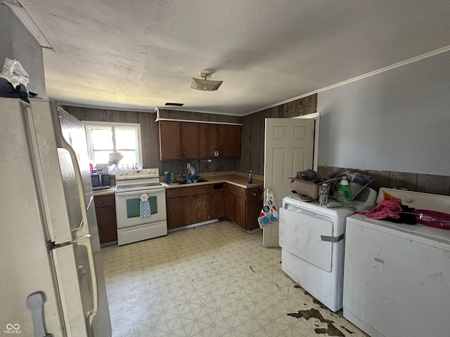 kitchen featuring white appliances, crown molding, dark brown cabinets, a textured ceiling, and washer and clothes dryer