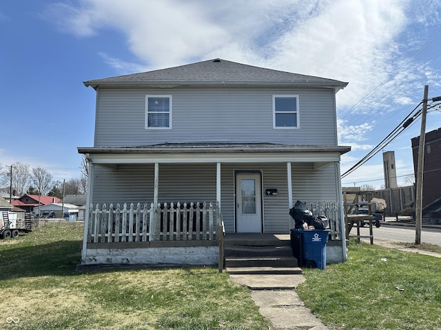 view of property featuring a porch and a front lawn