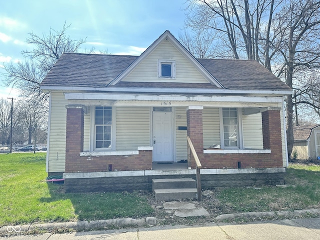 bungalow featuring covered porch and a front yard