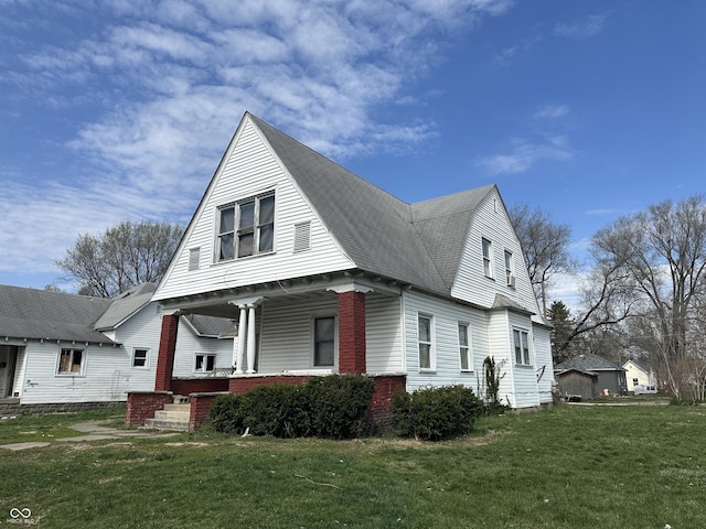 view of side of property featuring a yard and covered porch