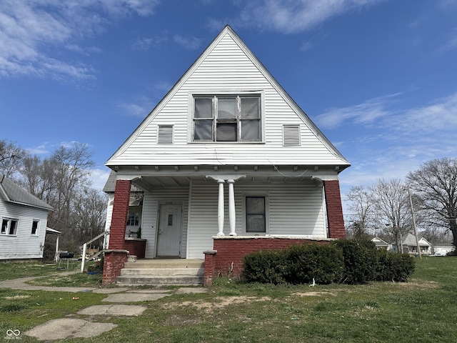 view of front of property with a front yard and covered porch