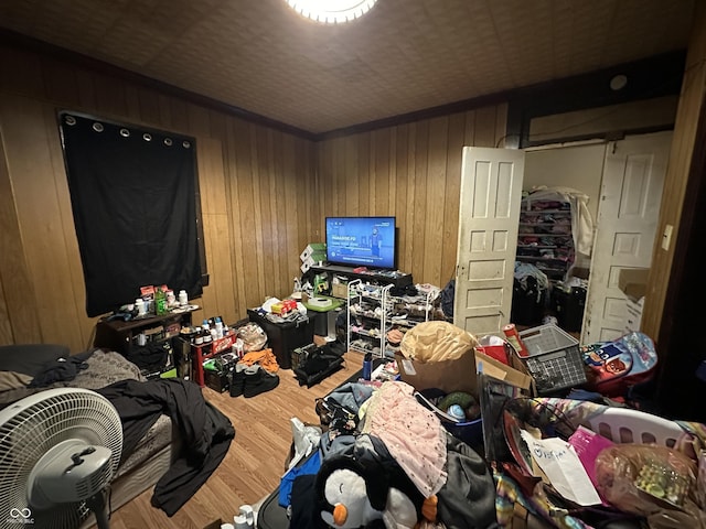 bedroom with hardwood / wood-style floors and wooden walls