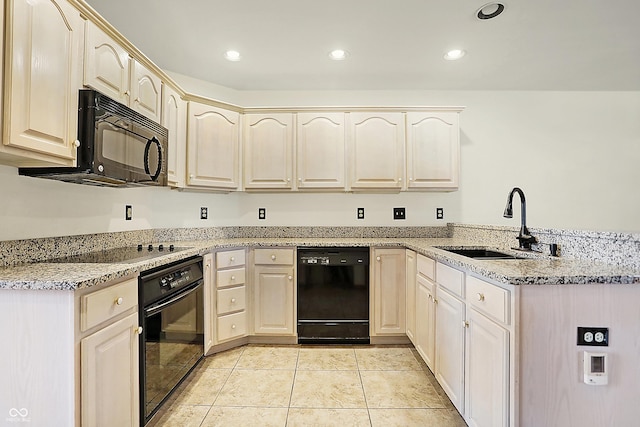 kitchen with light stone countertops, sink, kitchen peninsula, and black appliances