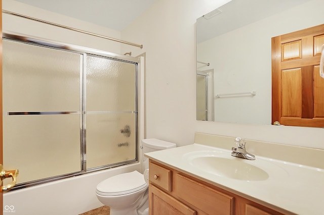 full bathroom with toilet, vanity, and bath / shower combo with glass door