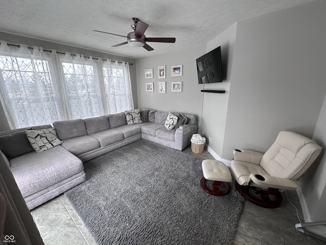 living room with ceiling fan and a textured ceiling