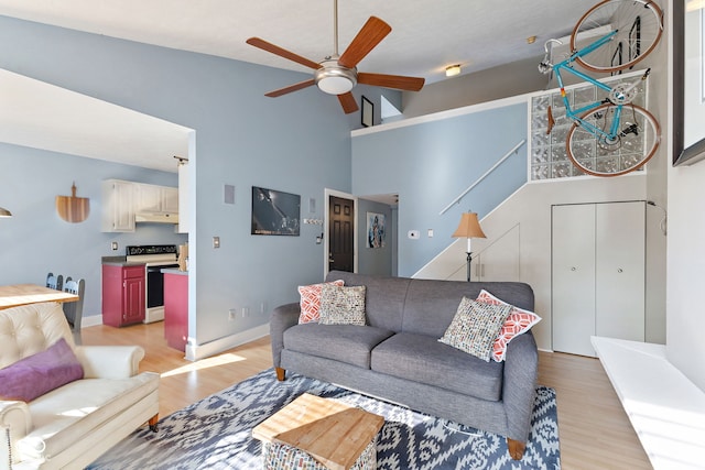 living room featuring high vaulted ceiling, ceiling fan, and light hardwood / wood-style flooring