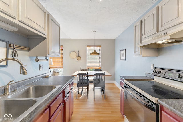 kitchen with sink, decorative light fixtures, a textured ceiling, electric range oven, and light hardwood / wood-style flooring